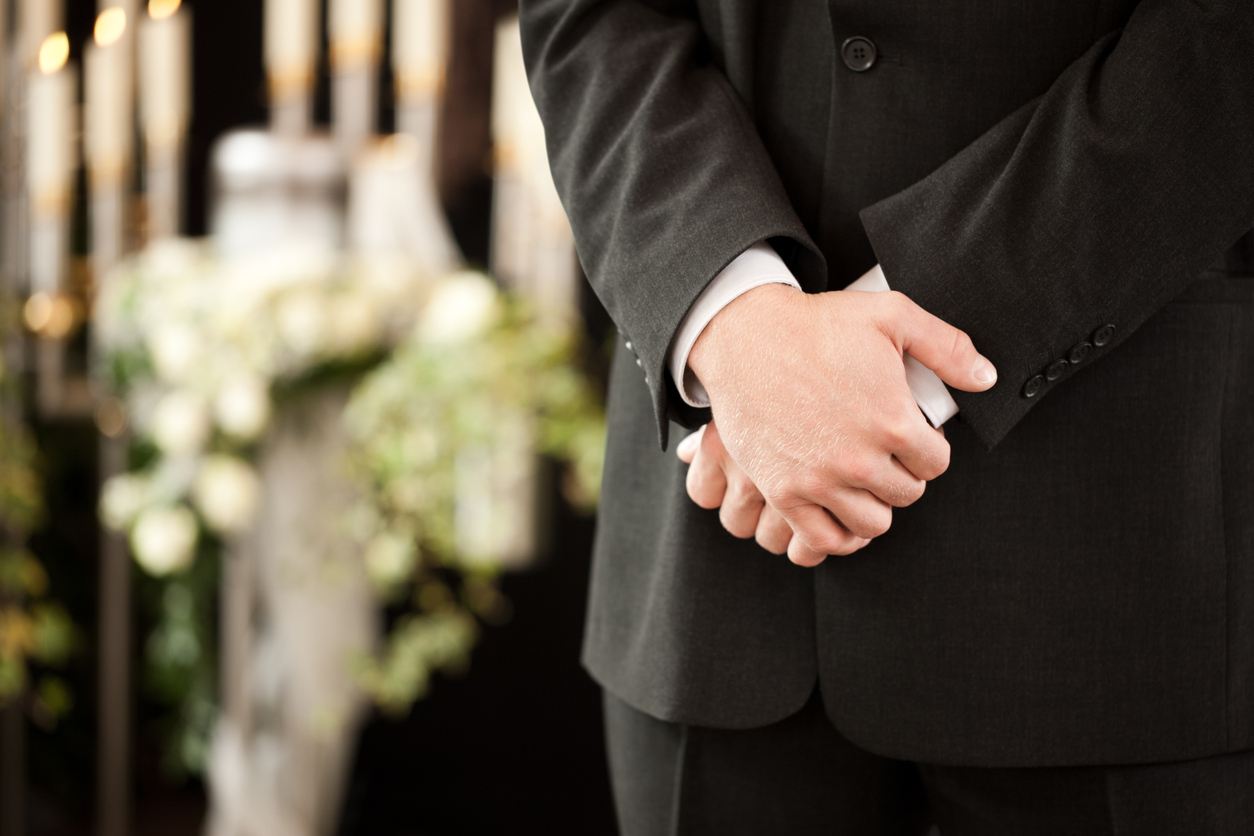 funeral attendee with arms crossed