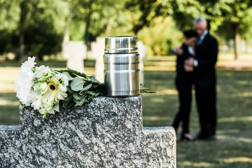 white flowers and cemetery urn for cremation