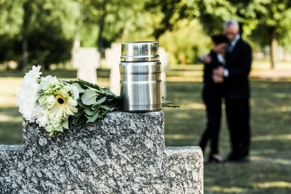 white flowers and cemetery urn for cremation