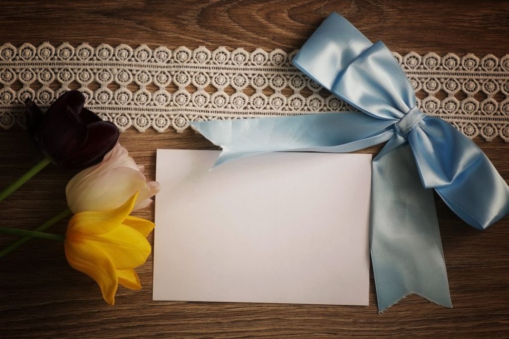 letter on table with ribbon and flowers