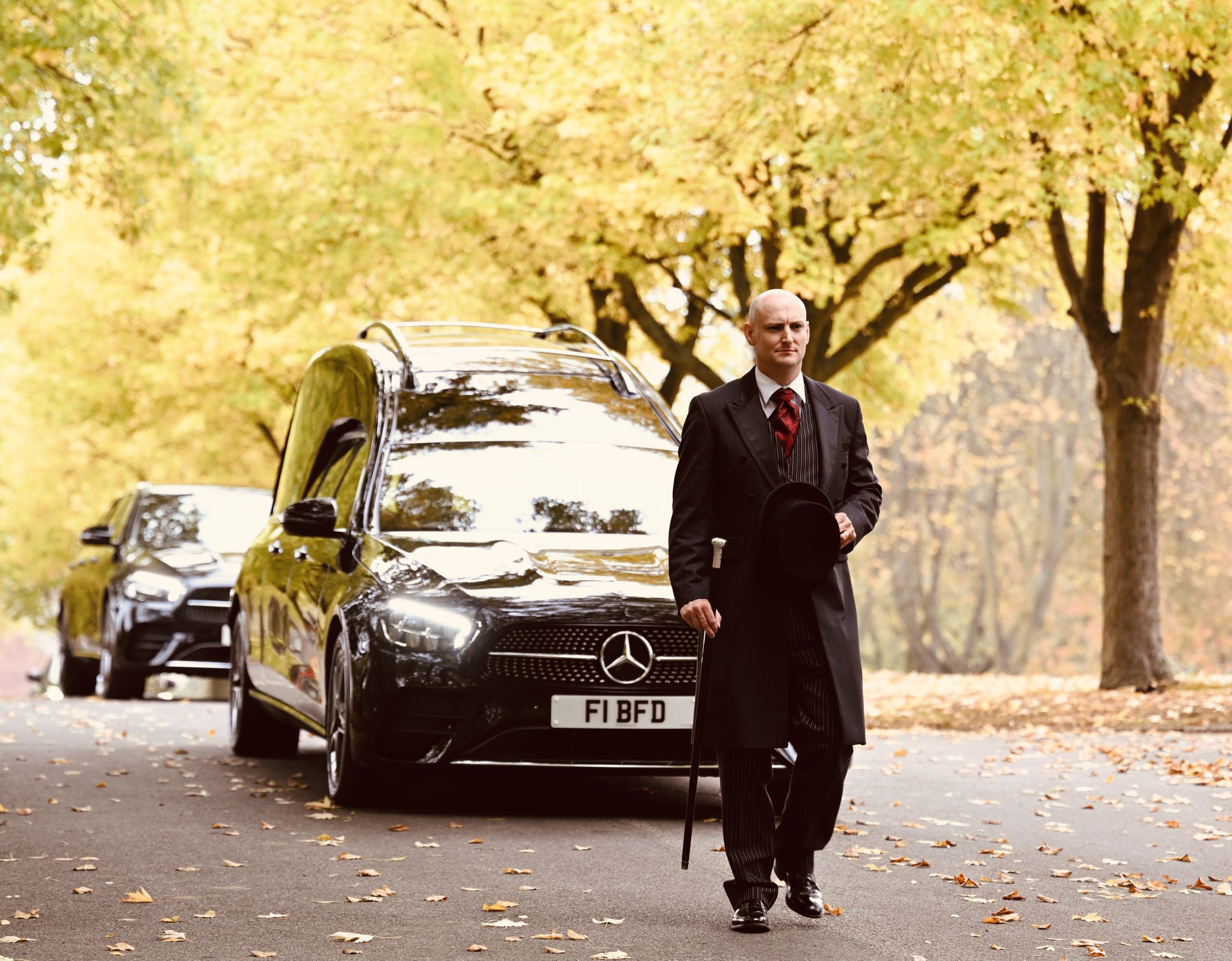 funeral director in front of hearse